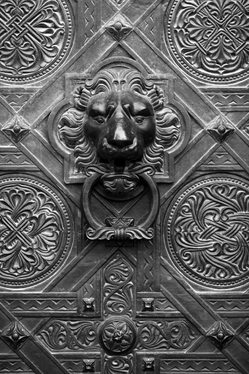 Black and white picture of an antique door knocker with a lion's head